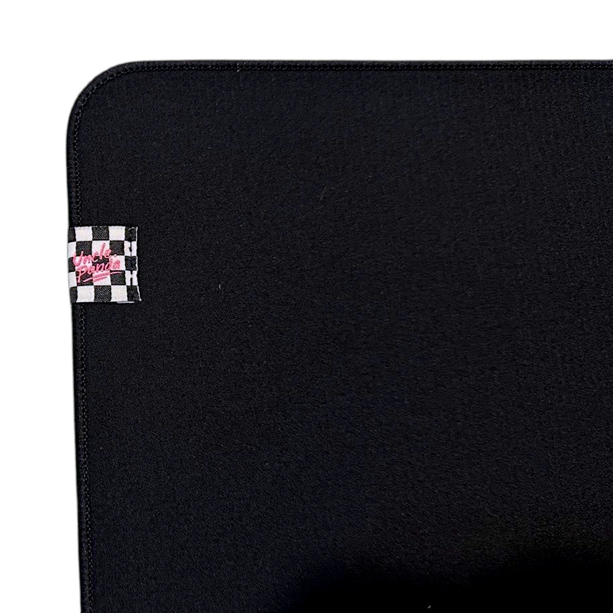 Oyuncu Baykuş marka, köşesinde damalı etiket detayı bulunan, dikişli kenarlara sahip siyah profesyonel oyuncu mouse pad